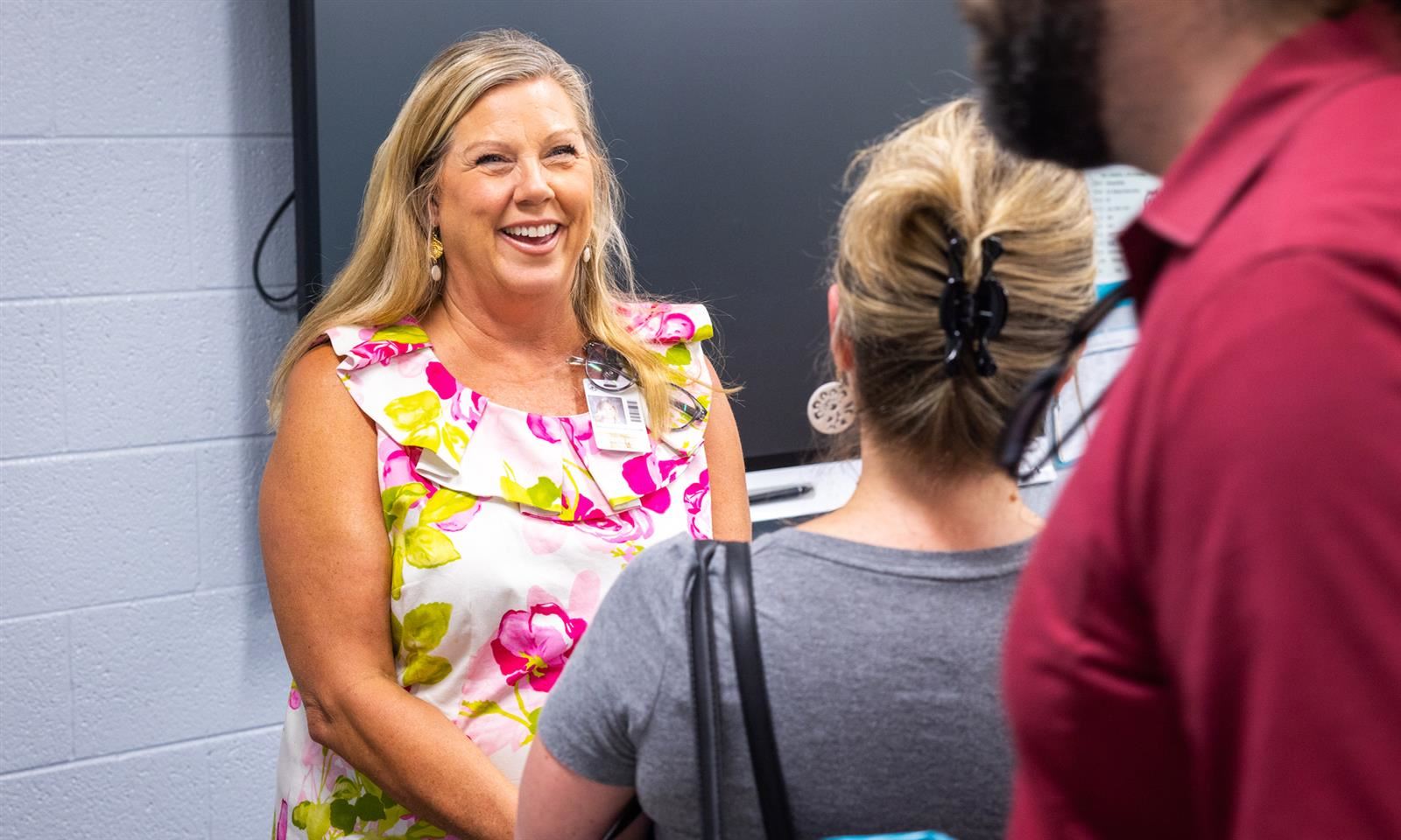 A teacher smiles at a parent